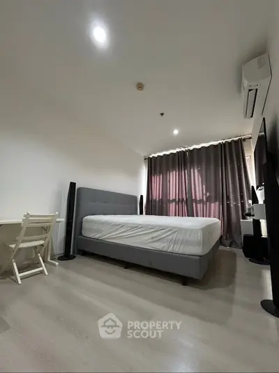 Modern bedroom with minimalist decor, featuring a comfortable bed and stylish curtains.