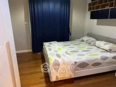 Cozy bedroom with wooden flooring and modern decor in a stylish apartment.