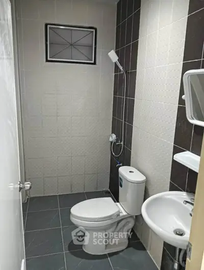 Modern bathroom with sleek tiles and compact fixtures, ideal for urban living spaces.