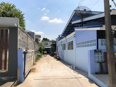 Charming residential property with blue exterior and satellite dish, featuring a spacious driveway.