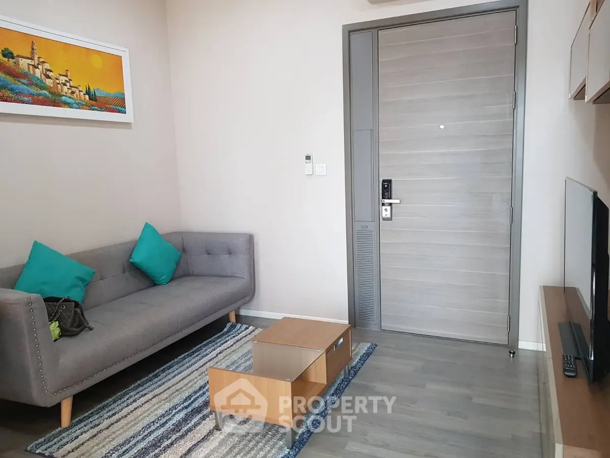Modern living room with stylish sofa, vibrant artwork, and sleek wooden flooring.
