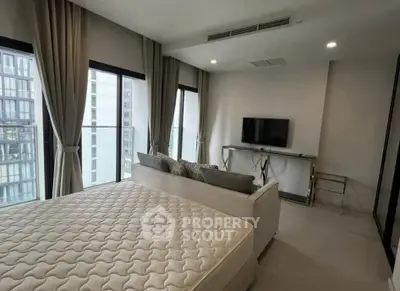 Modern bedroom with large windows and minimalist decor in urban apartment