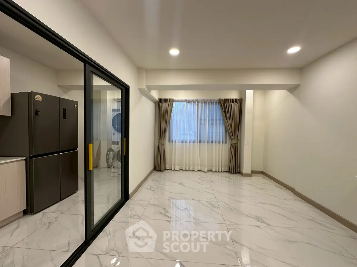 Spacious modern apartment with sleek kitchen and elegant marble flooring.