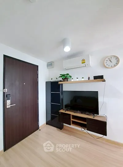 Modern living room with sleek TV setup and wooden flooring