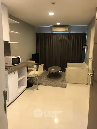 Modern living room with cozy seating and compact kitchen area