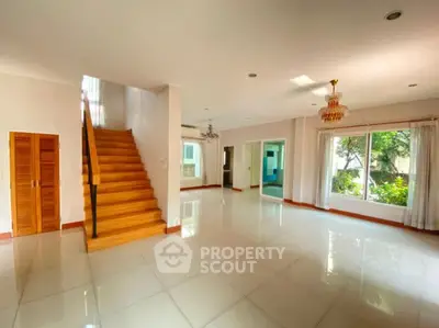 Spacious modern living room with elegant staircase and large windows