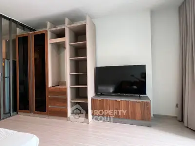 Modern bedroom with sleek TV stand and open wardrobe design