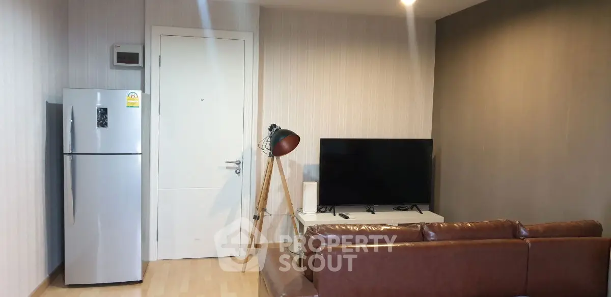 Modern living room with sleek furniture and appliances, featuring a stylish floor lamp and a flat-screen TV.