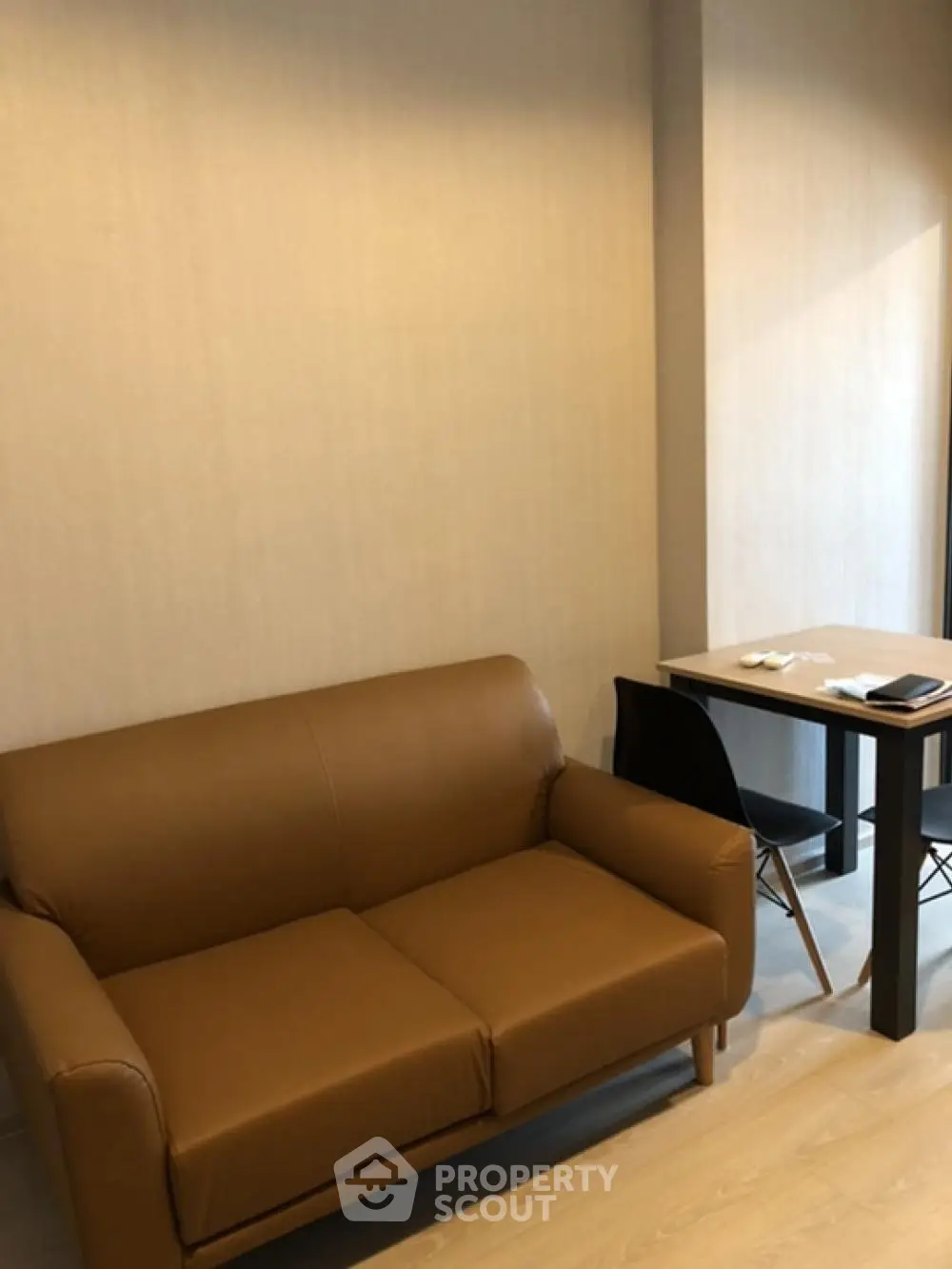 Modern living room with brown leather sofa and minimalist dining table