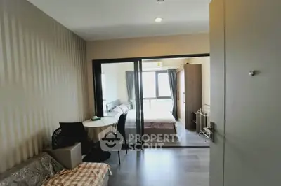 Modern apartment interior with bedroom and living area, featuring glass partition and stylish decor.