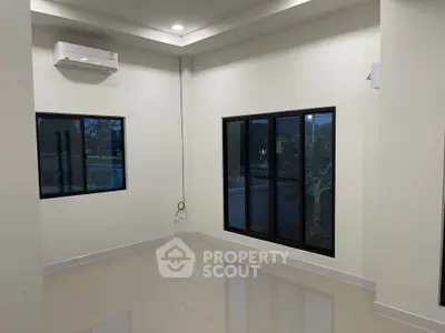 Spacious empty room with large windows and air conditioning, perfect for customization.