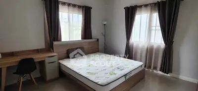 Spacious bedroom with natural light and modern furnishings, ideal for comfort and relaxation.