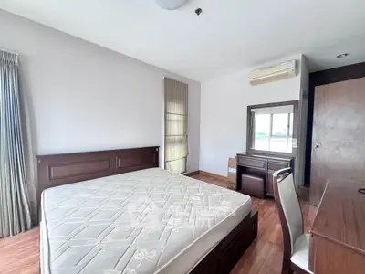 Spacious bedroom with wooden furniture and natural light