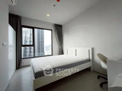 Modern bedroom with large window and city view, featuring minimalist furniture and neutral tones.