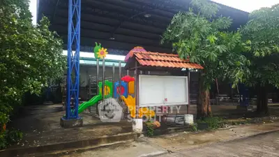 Spacious outdoor playground area with colorful slides and covered seating, ideal for family-friendly properties.