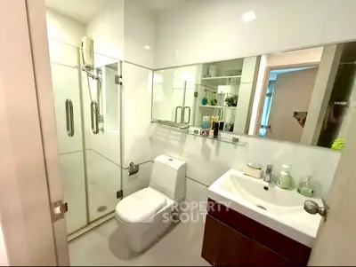 Modern bathroom with glass shower and sleek fixtures in a contemporary apartment.