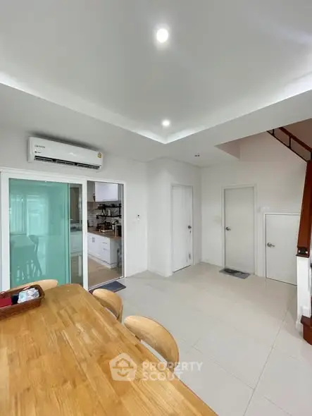 Modern dining area with wooden table and open kitchen layout