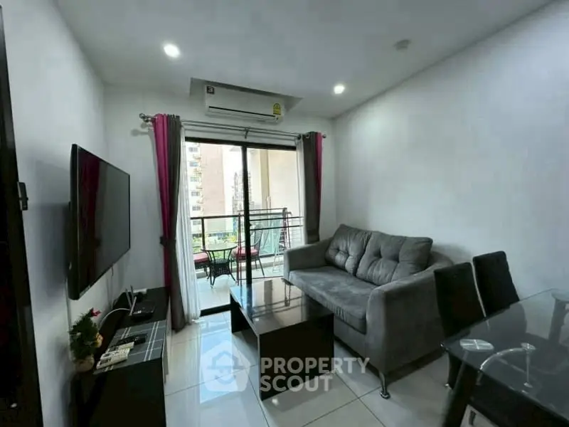 Modern living room with balcony view, stylish furniture, and natural light.
