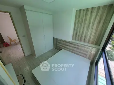 Modern bedroom with built-in wardrobe and large window offering natural light.