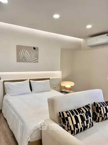 Modern bedroom with stylish decor and cozy lighting, featuring a comfortable bed and chic pillows.