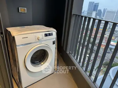 High-rise balcony with washing machine and stunning city view, perfect for urban living.