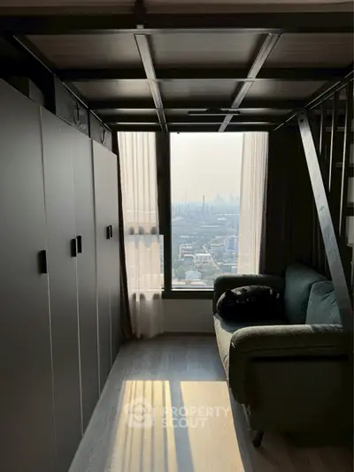 Modern loft apartment with stunning city view and cozy seating area.
