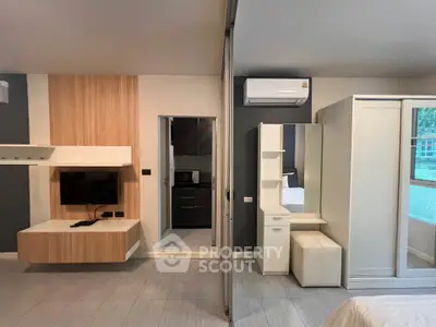 Modern bedroom with sleek design, featuring a wall-mounted TV, air conditioning, and stylish furniture.