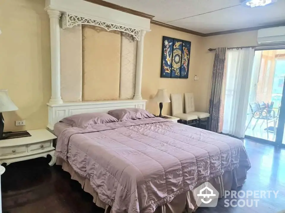 Elegant master bedroom with classic decor, large bed, and access to a sunlit balcony, perfect for upscale living.