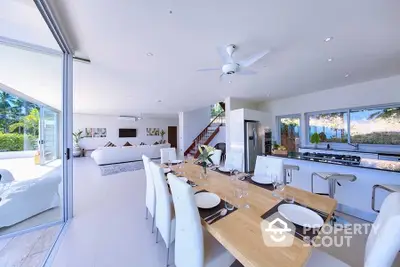 Spacious open-plan living and dining area with modern kitchen and garden view.