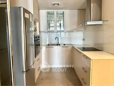 Modern kitchen with sleek cabinetry, stainless steel appliances, and a glass backsplash in a contemporary apartment.
