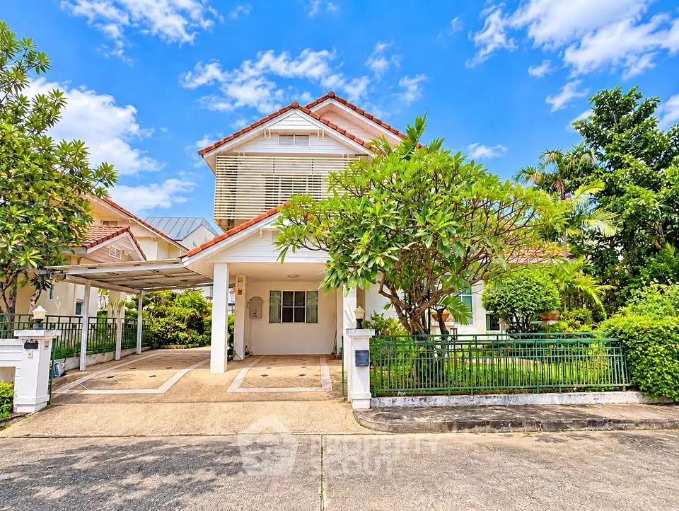Charming two-story house with lush garden and carport in a serene neighborhood.