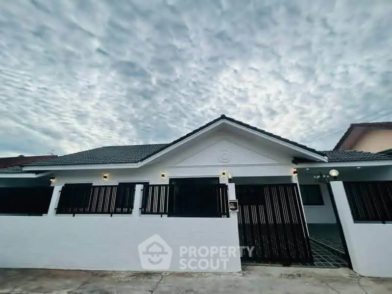 Charming single-story home with modern facade and dramatic sky backdrop, perfect for family living.