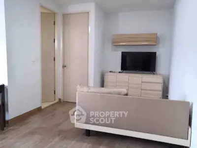 Modern living room with sleek furniture and mounted TV in a cozy apartment setting.