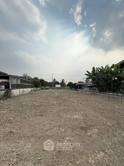 Spacious vacant land with potential for development under a clear sky.