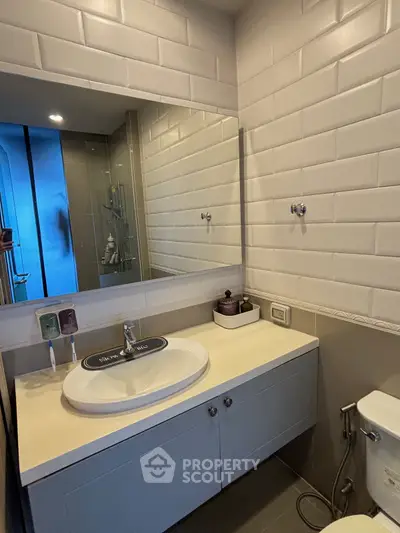 Modern bathroom with sleek vanity and large mirror in stylish apartment.
