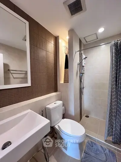 Modern bathroom with sleek fixtures and walk-in shower in contemporary apartment.