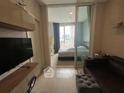 Modern apartment with cozy living room and bedroom, featuring sleek furniture and natural light.