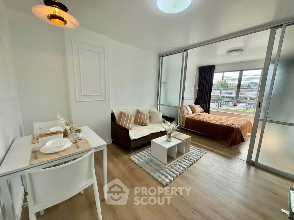 Modern open-plan living room with cozy bedroom and stylish decor in a bright apartment.