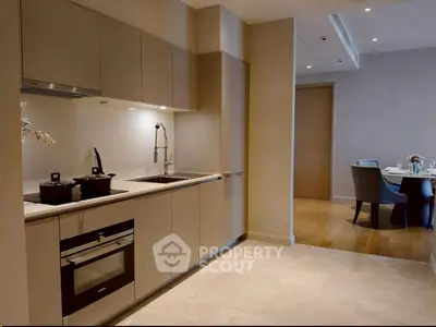 Modern kitchen with sleek cabinetry and dining area in luxury apartment