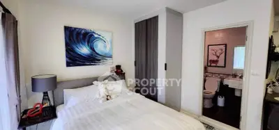 Cozy bedroom with ensuite bathroom, featuring modern decor and ample natural light.