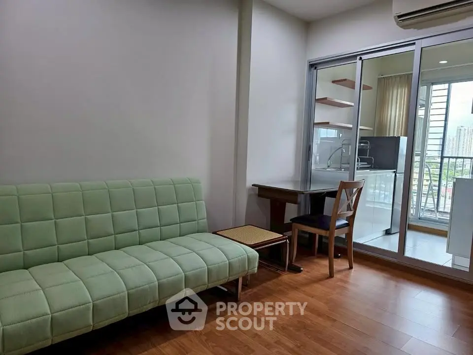 Modern living room with green sofa and balcony view in urban apartment