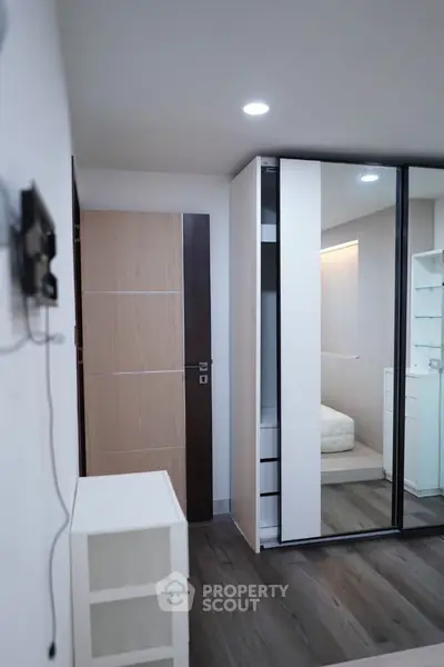 Modern bedroom with sleek design and mirrored wardrobe