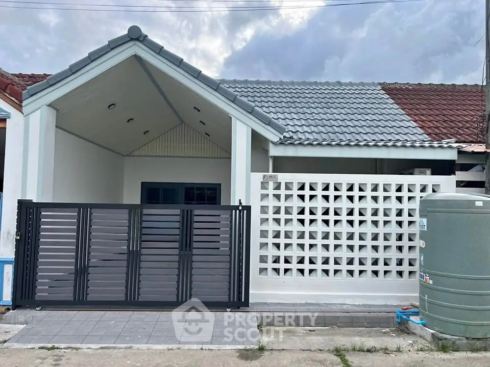 Charming single-story home with modern facade and gated entrance, perfect for cozy living.