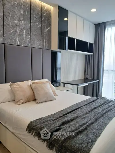 Modern bedroom with stylish decor and natural light, featuring a cozy bed and sleek built-in storage.