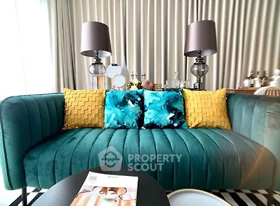 Stylish living room with teal sofa and vibrant cushions, perfect for modern interiors.