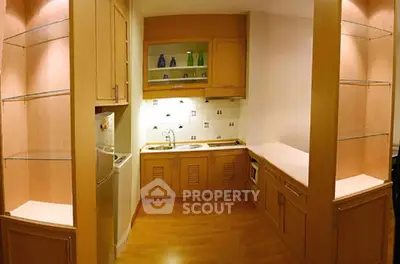 Charming compact kitchen with wooden cabinetry and modern appliances, perfect for cozy urban living.