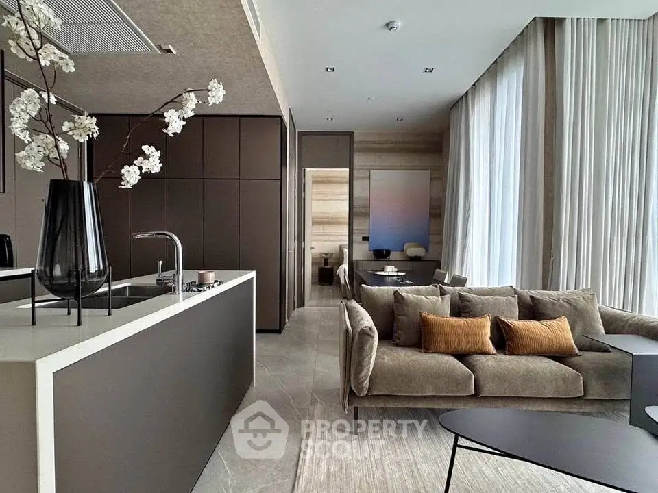 Luxurious modern living room with open kitchen, elegant decor, and floor-to-ceiling windows.