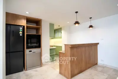 Modern kitchen with wooden accents, built-in appliances, and stylish lighting fixtures.