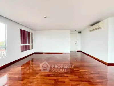 Spacious living room with polished wooden floors and natural light.