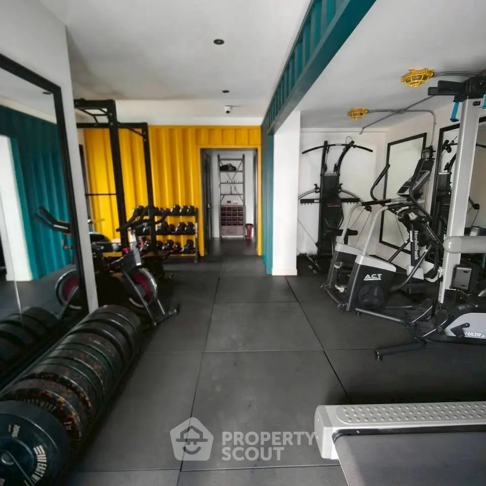 Modern home gym with vibrant yellow and teal accents, featuring state-of-the-art fitness equipment.